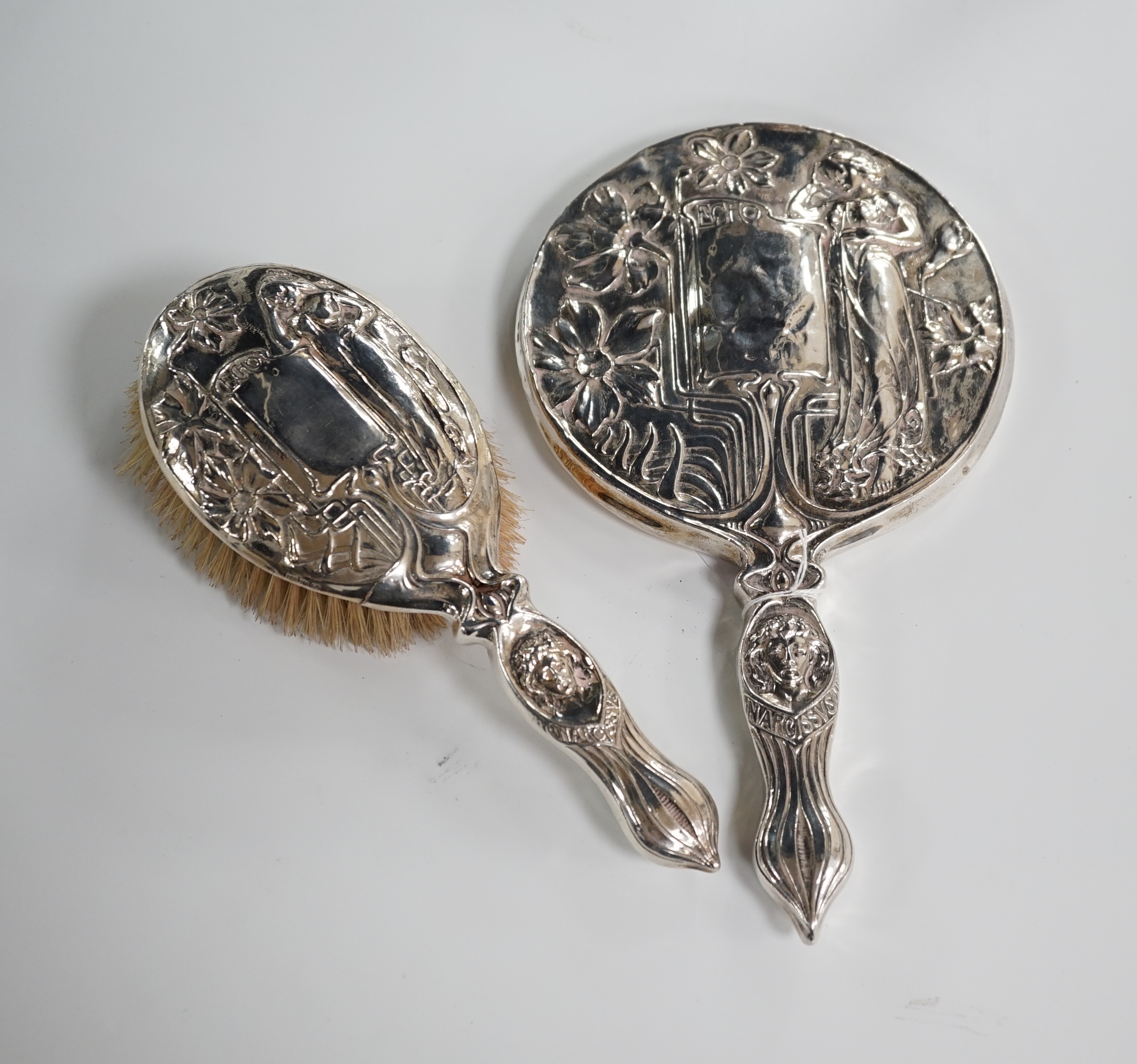 A late Victorian Art Nouveau silver mounted hand mirror, marks rubbed, 27.8cm. and a later similar hair brush, London 1902. Condition - poor